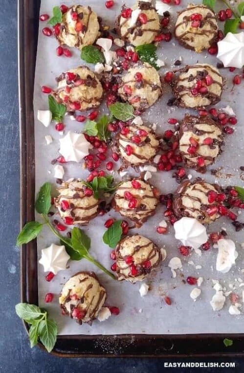 low carb coconut cookies in a baking sheets with pomegranate seeds and meringues
