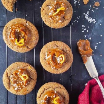 cinnamon cookies topped with dulce de leche over a rack with coarse salt sprinkles