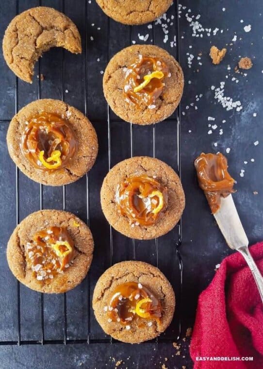 Cinnamon cookies topped with dulce de leche over a rack with coarse salt sprinkles