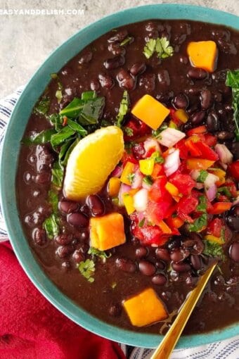 A bowl of vegetarian feijoada with garnishes on top