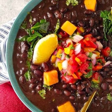 A bowl of vegetarian feijoada with garnishes on top