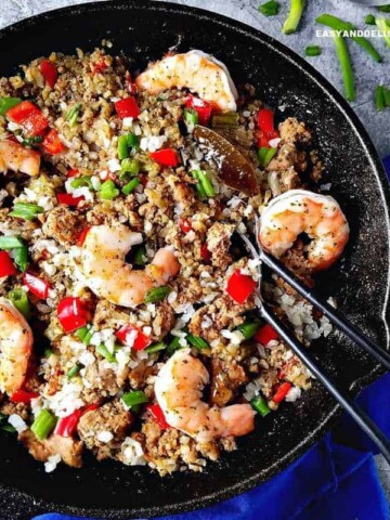 Cajun dirty rice with shrimp in a skillet and silveware on the side