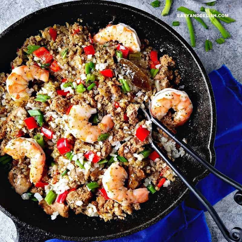 Cajun dirty rice with shrimp in a skillet and silveware on the side