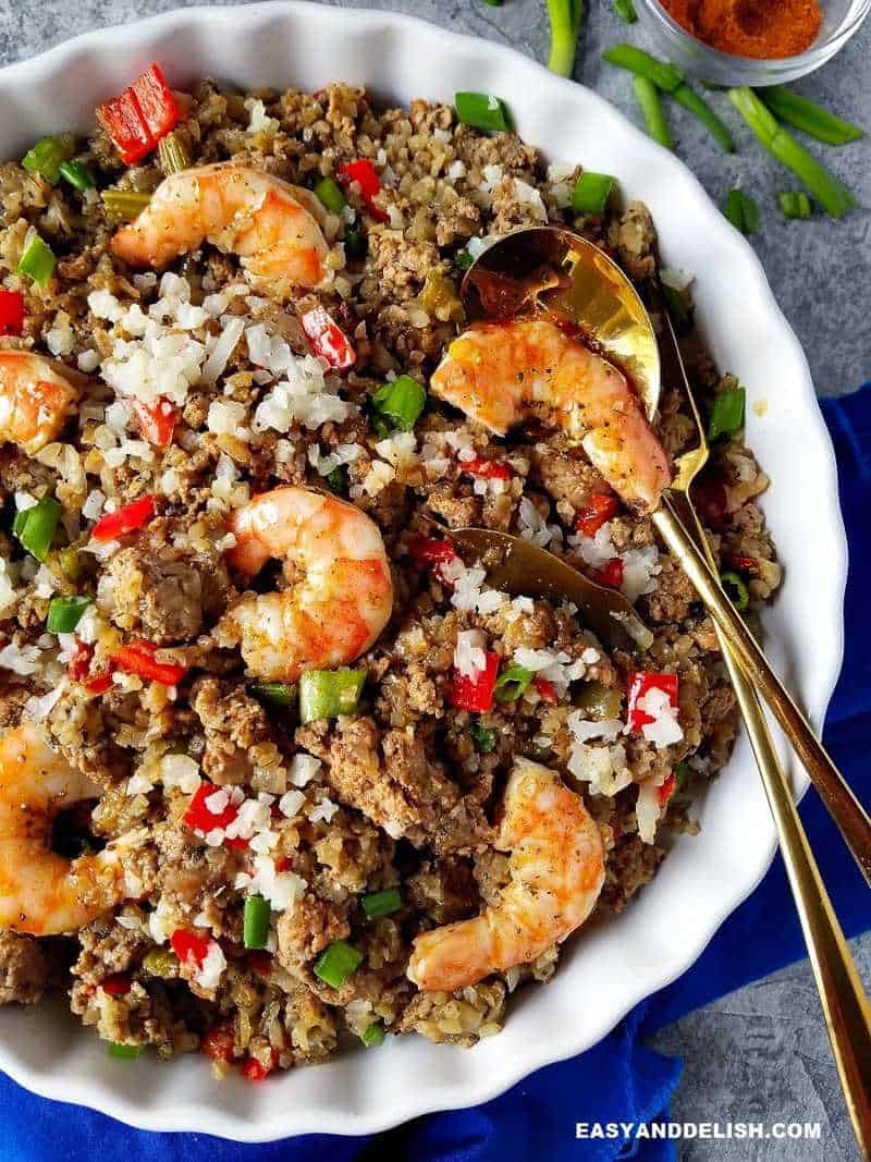 Cajun dirty rice with shrimp in a plate and spoon on the side