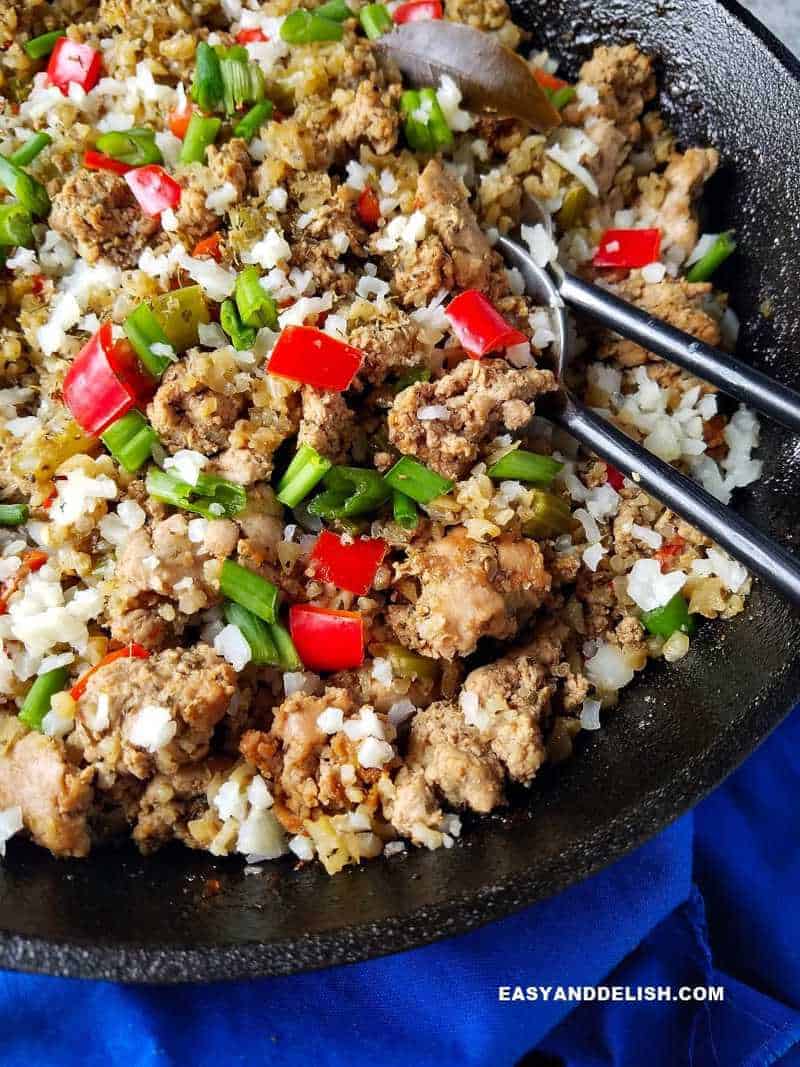 close up of dirty rice with spoon on the side