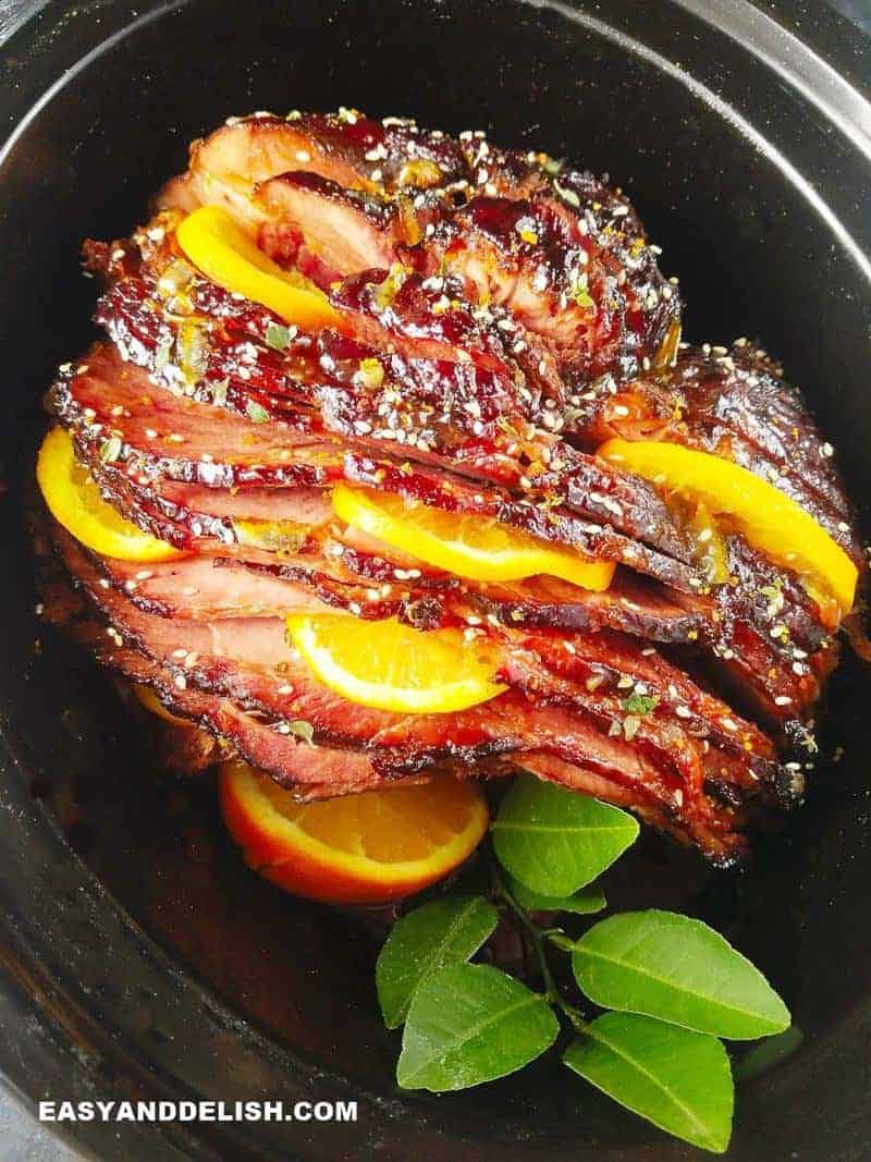 Sliced ham with orange slices in the slow cooker