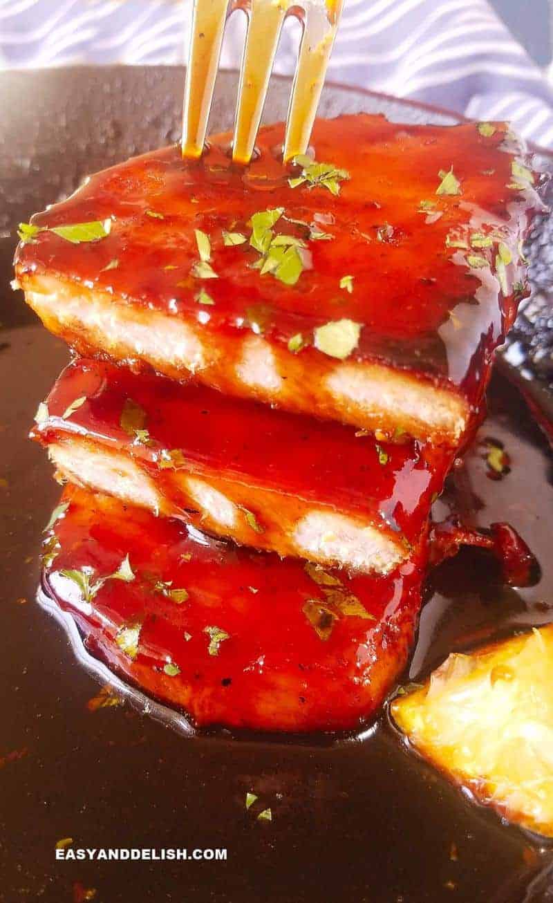 broiled pork chops piled up with a fork on top