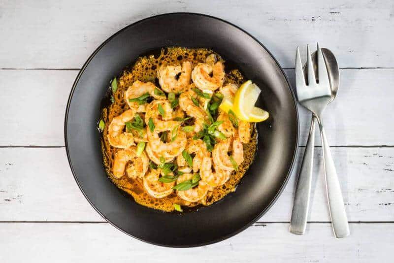 shrimp and lemon in a plate with silverware on the side