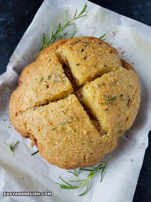 baked loaf garnished with rosemary sprigs on a baking sheet