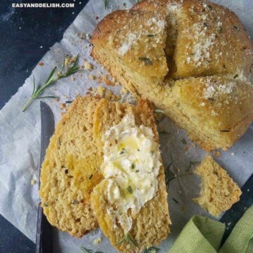 a loaf of no yeast bread partially sliced with butter on top