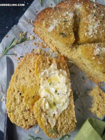 a loaf of no yeast bread partially sliced with butter on top