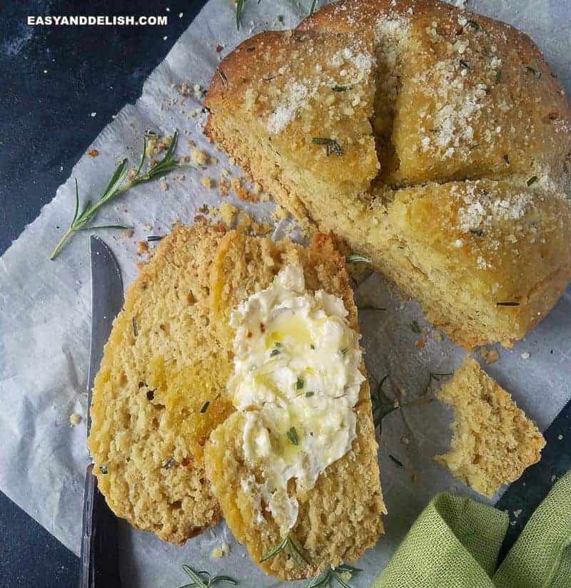 a loaf of no yeast bread partially sliced with butter on top