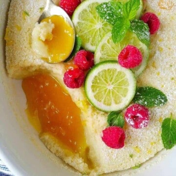 close up de bolo de limao com fatias de limao no topo e frutas vermelhas