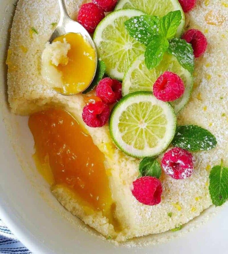 close up de bolo de limao com fatias de limao no topo e frutas vermelhas