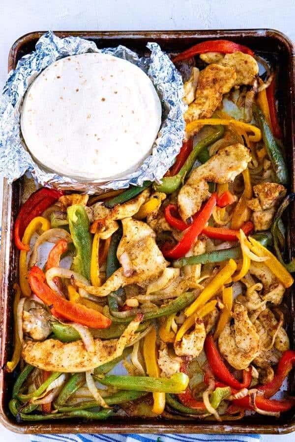 chicken fajitas in a sheet pan with sauce on the side one of the easy one pot meals