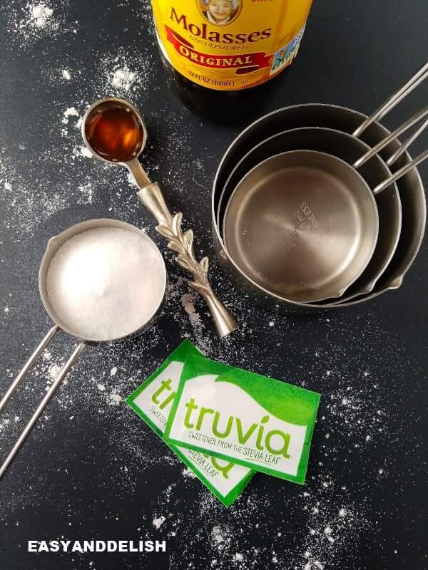 measruing cups with sugar and molasses in a spoon for baking substitutions