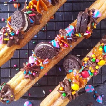 churros gourmet decorados sobre uma grade