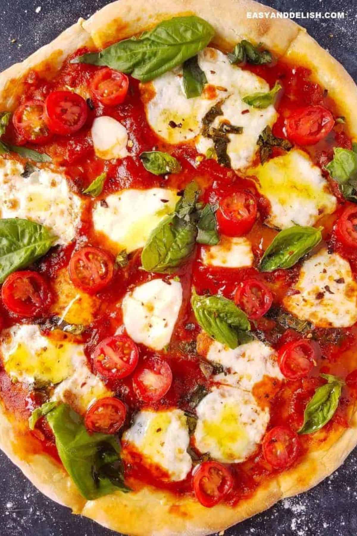 Margherita pizza topped with fresh mozzarella, cherry tomatoes, basil, and red pepper flakes.