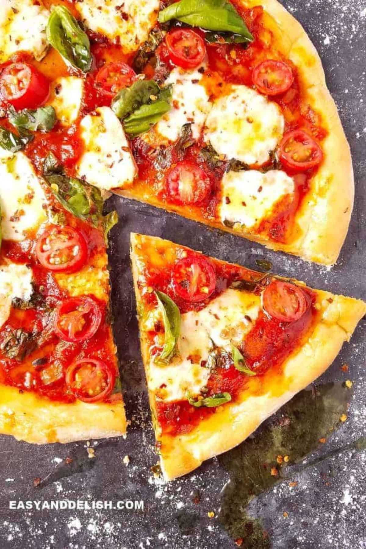 Unbaked pizza dough spread with tomato sauce and topped with fresh mozzarella and basil.