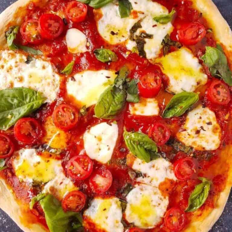 Homemade pizza topped with tomato sauce, fresh mozzarella, cherry tomatoes, and basil.