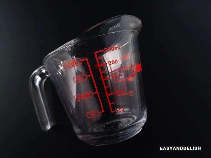 a measuring cup with marks in cups and milliliters for volume conversions and measurements 