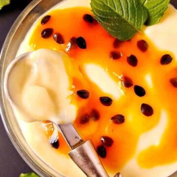 close up of passion fruit mousse with coulis being spooned