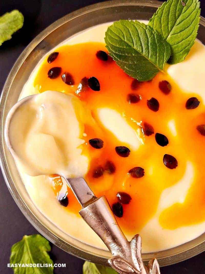 close up of passion fruit mousse with coulis being spooned