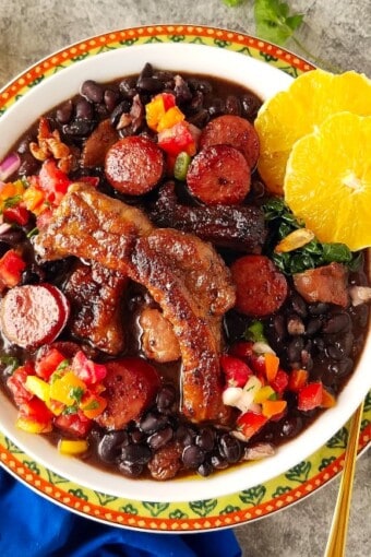 um prato de feijoada simples e seus acompanhamentos