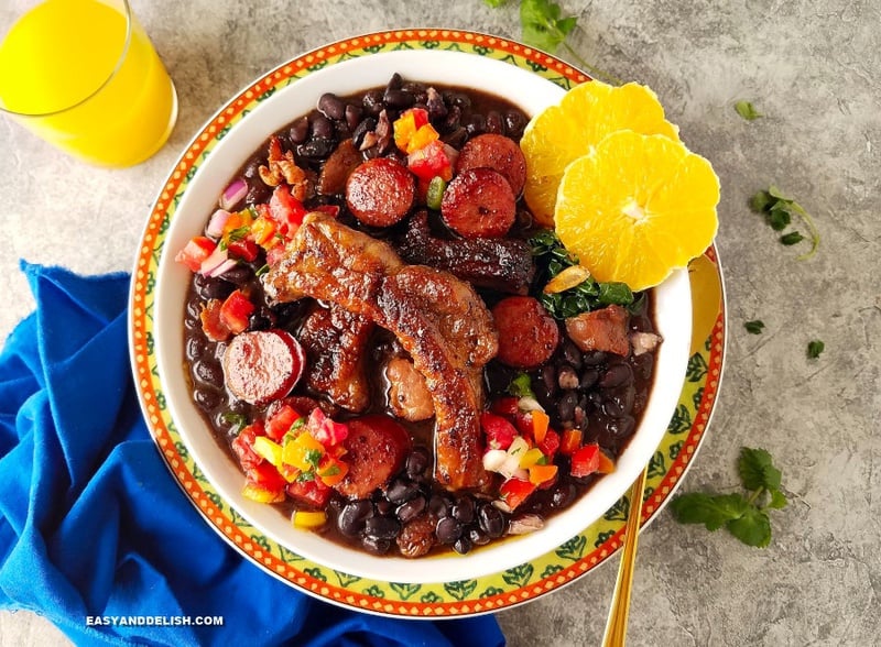 um prato de feijoada com acompanhamentos