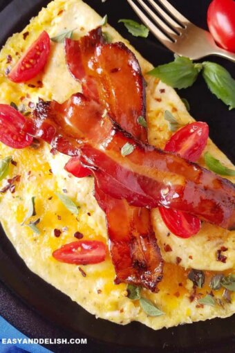 close up of an easy omelette filled with cheese and topped with bacon and herbs