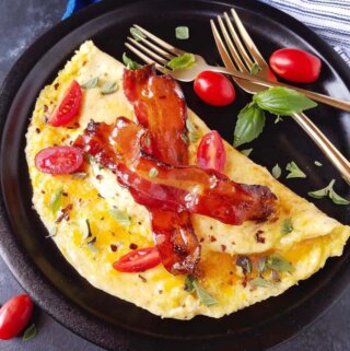 omelete simples em um prato com queijo, bacon e verduras