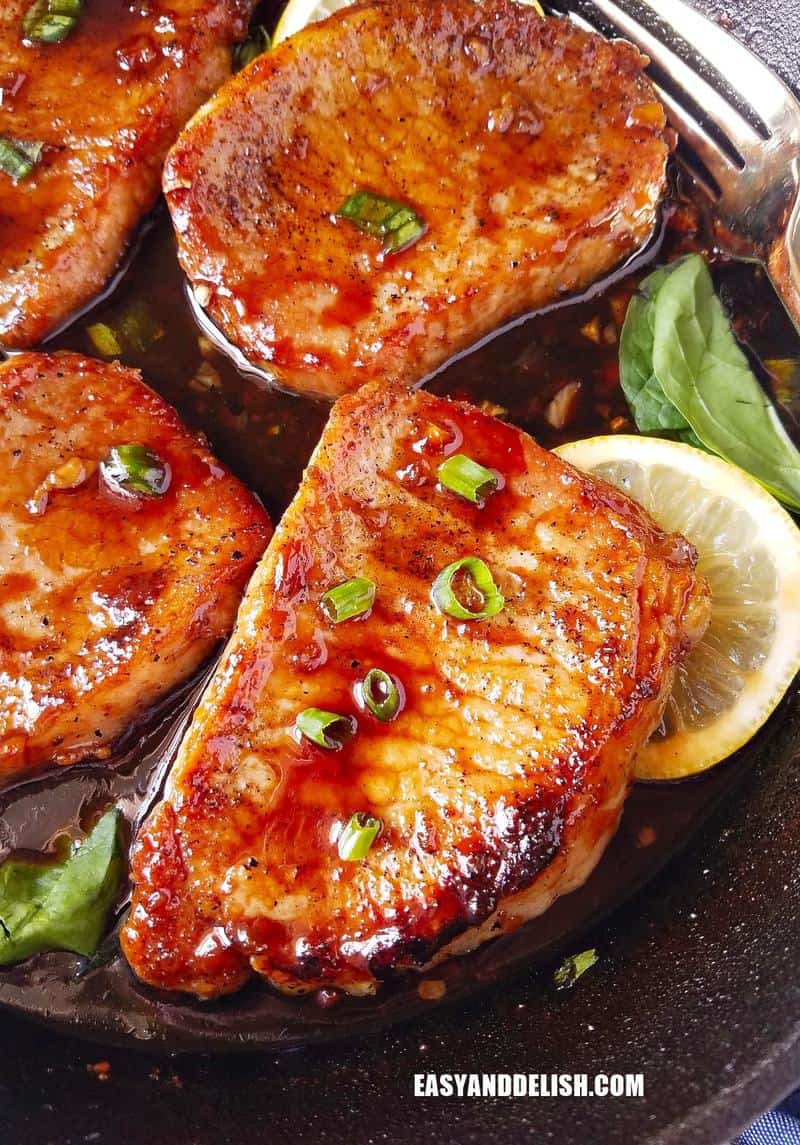 several chops in a pan garnished with lemon slices