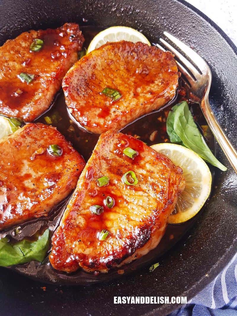 close up of pan-seared pork chops in a skillet as one of 30 high portein dinners