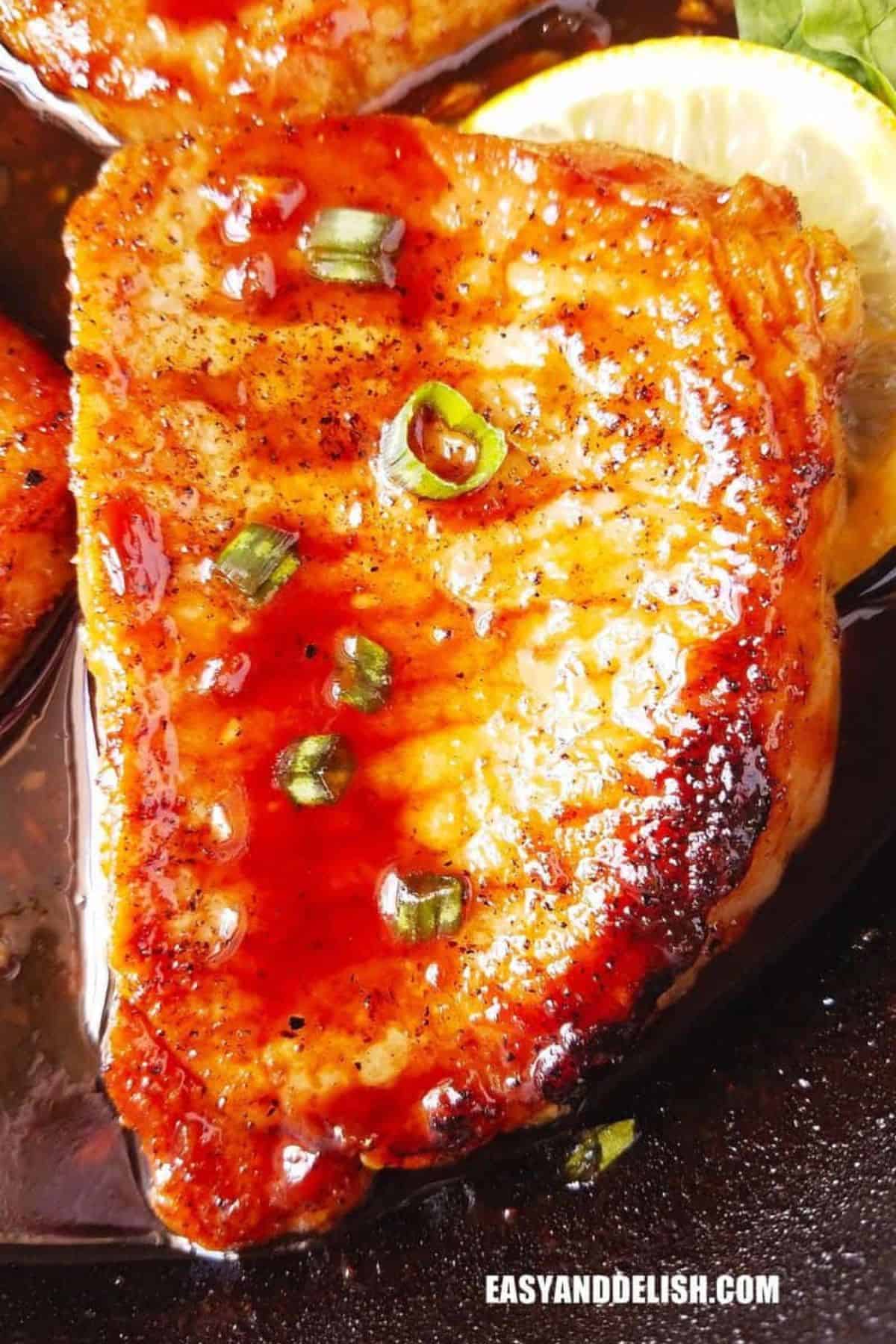 Pan-Seared Pork Chops coated with a glossy teriyaki glaze and topped with green onions.