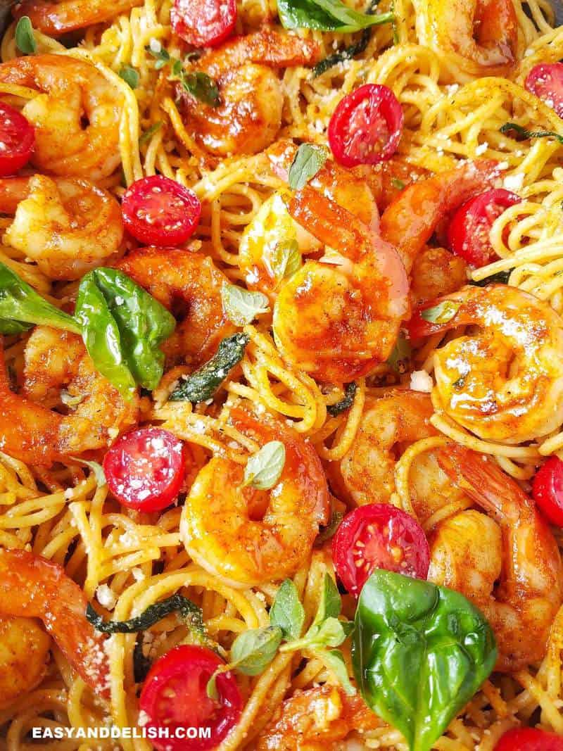 close up of shrimp spaghetti with spinach and tomatoes