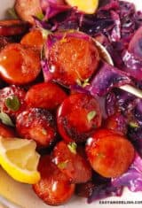 closeup de repolho refogado com linguiça sendo comido com uma colher