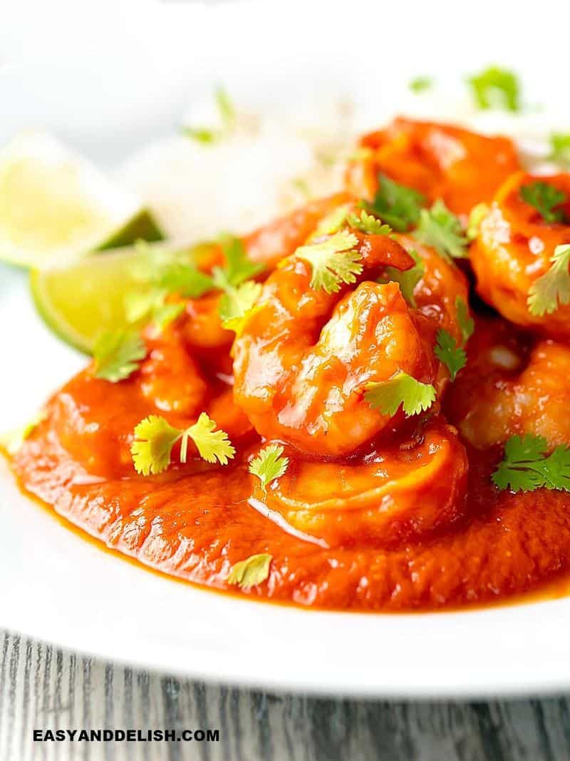close up of deviled shrimp in a pool of sauce in a plate
