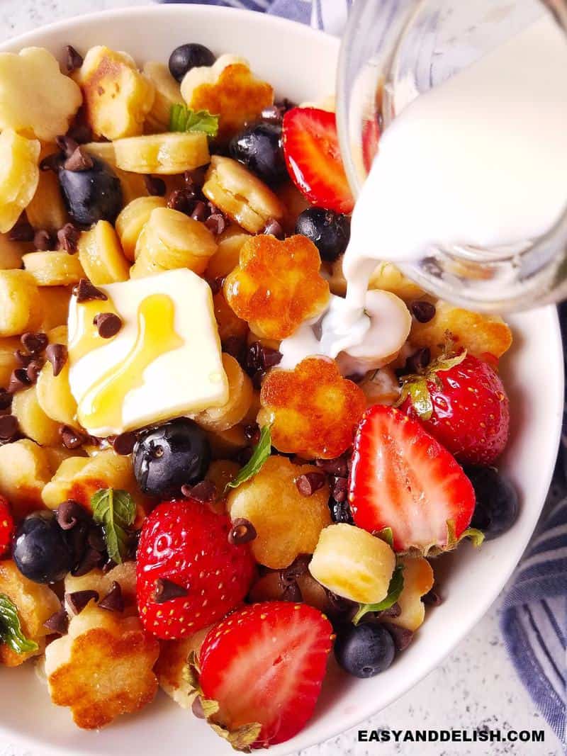 milk being pourd over mini pancake cereal