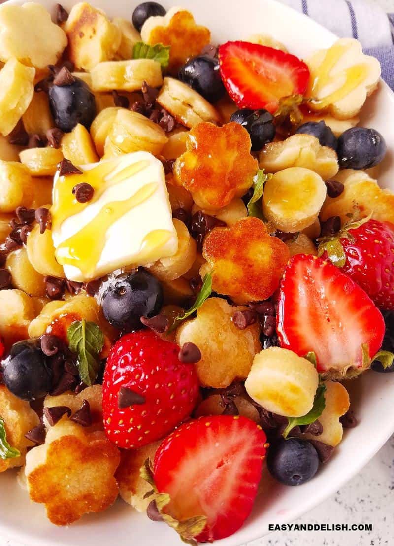 close up of breakfast in a bowl with butter, honey, and fruits