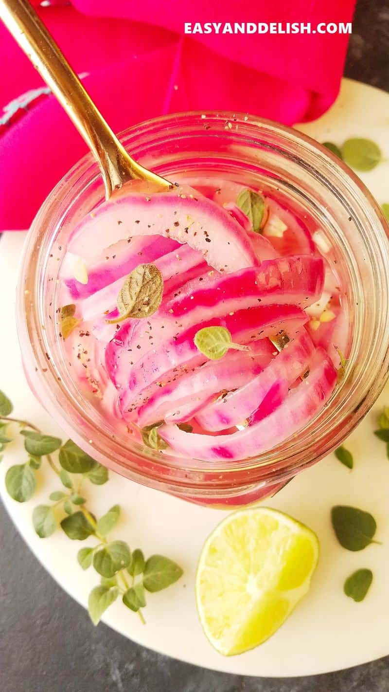 Mexican pickled red onions ina jar and garnishes on the side