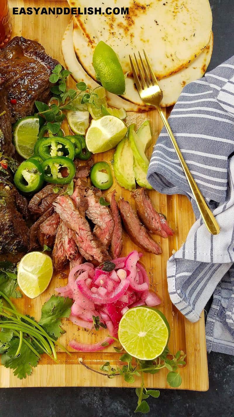 meat, partially sliced on a cutting booard and some sides