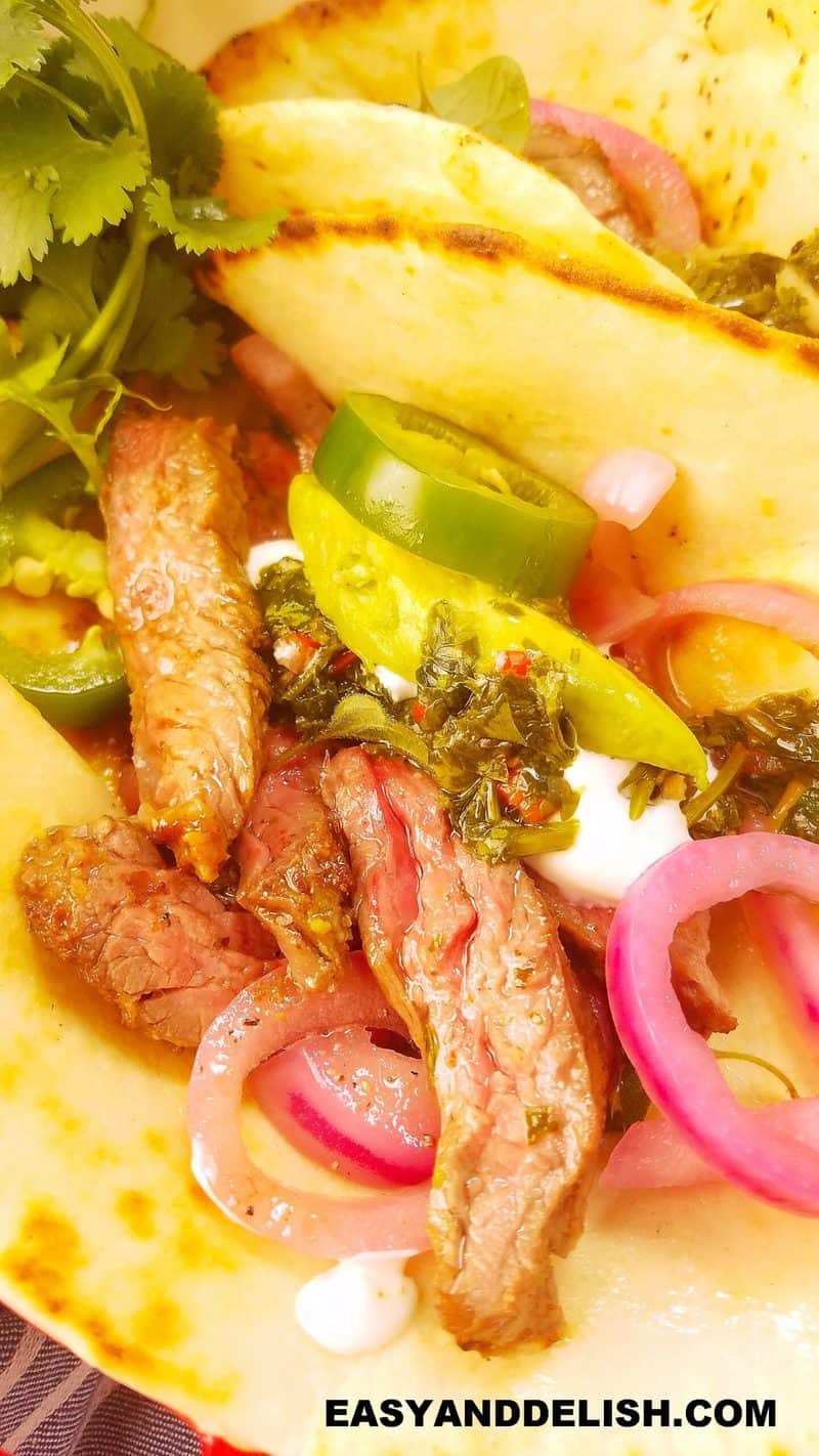 close of a taco with skirt steak and sides