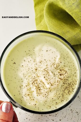 Female barista hands preparing matcha tea on a bowl, mixing it