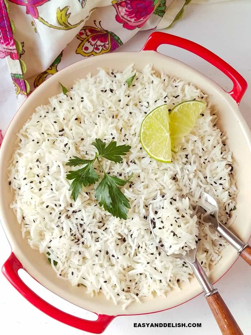 a bowl of basmati rice with sesame seeds and lime slices
