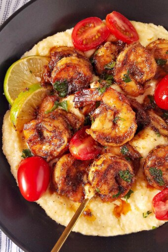 close up image showing a bowl with blackened shrimp over grits