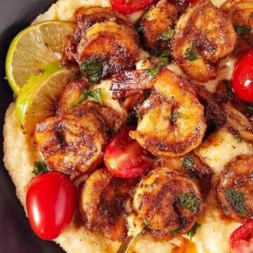 close up image showing a bowl with blackened shrimp over grits
