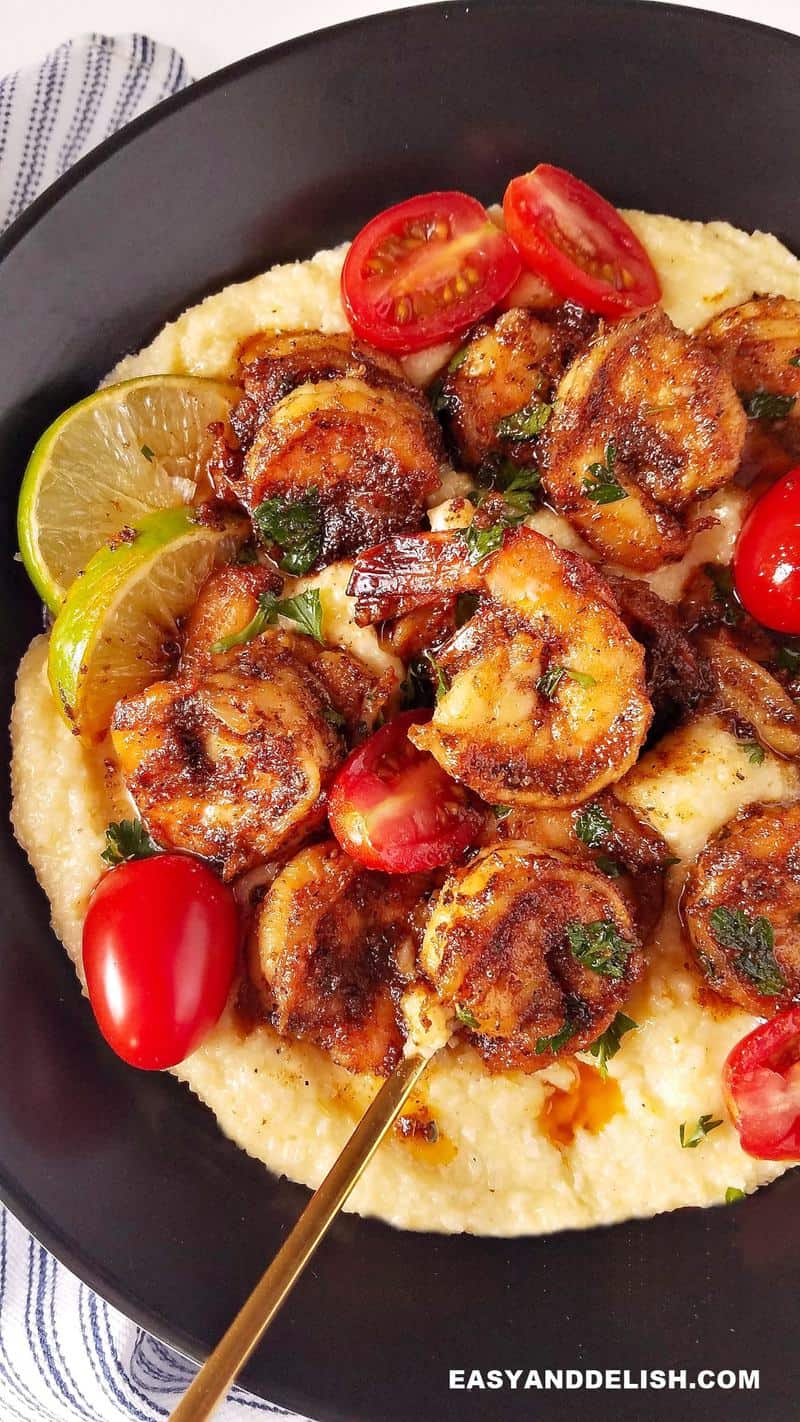 close up image showing a bowl with blackened shrimp over grits