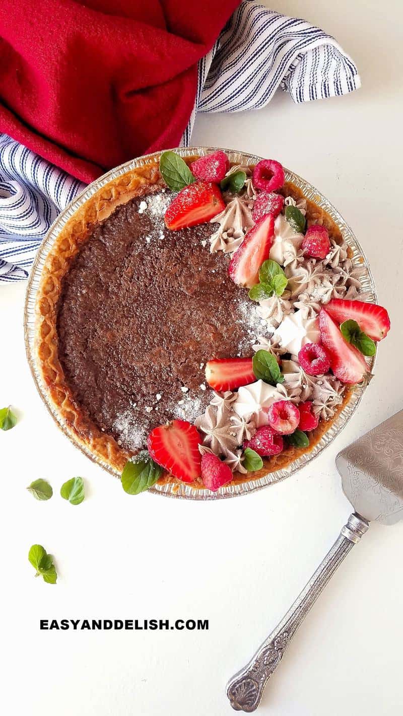 a chocolate chess pie decorated on top with a spatula on the side