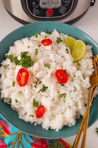 A plate of rice topped with lime and hot peppers