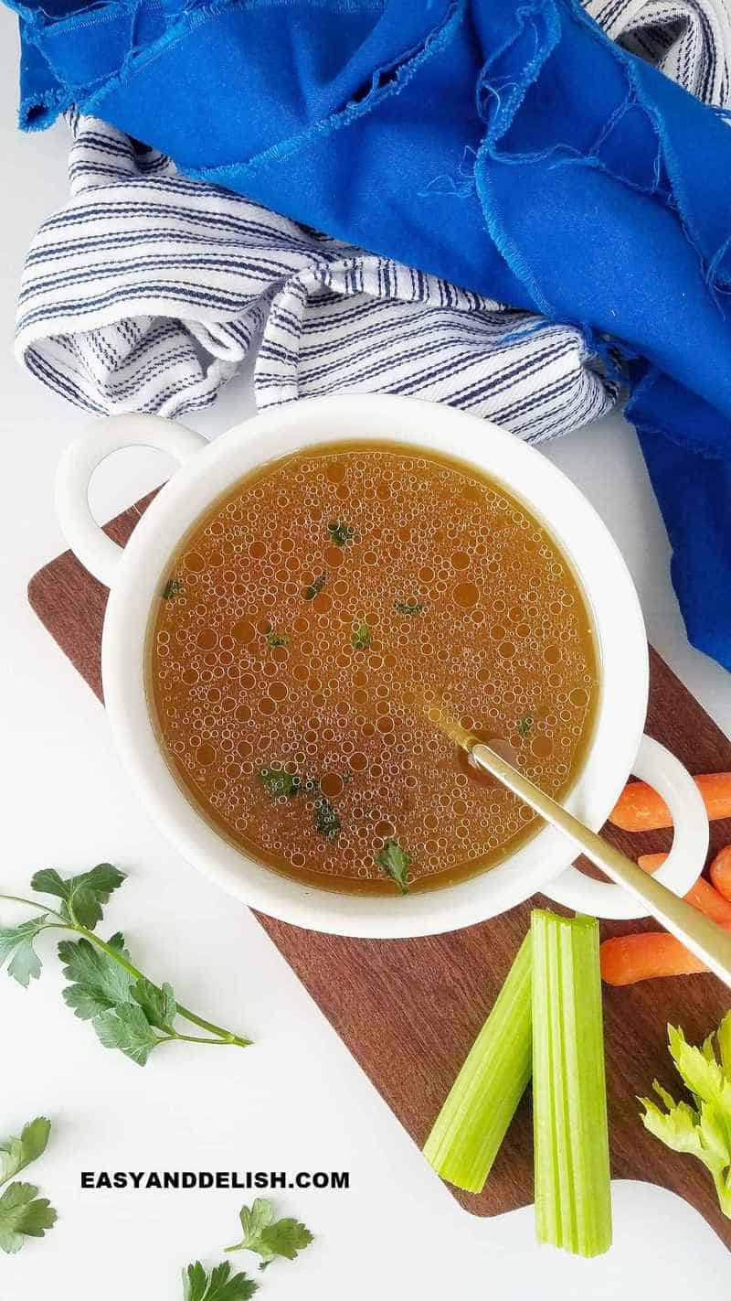 stock in a bowl with veggies on the side